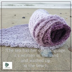 De quote van de Zandlijnen Shawl: The sea has her own language, it's written in the sand and washed up at the beach.